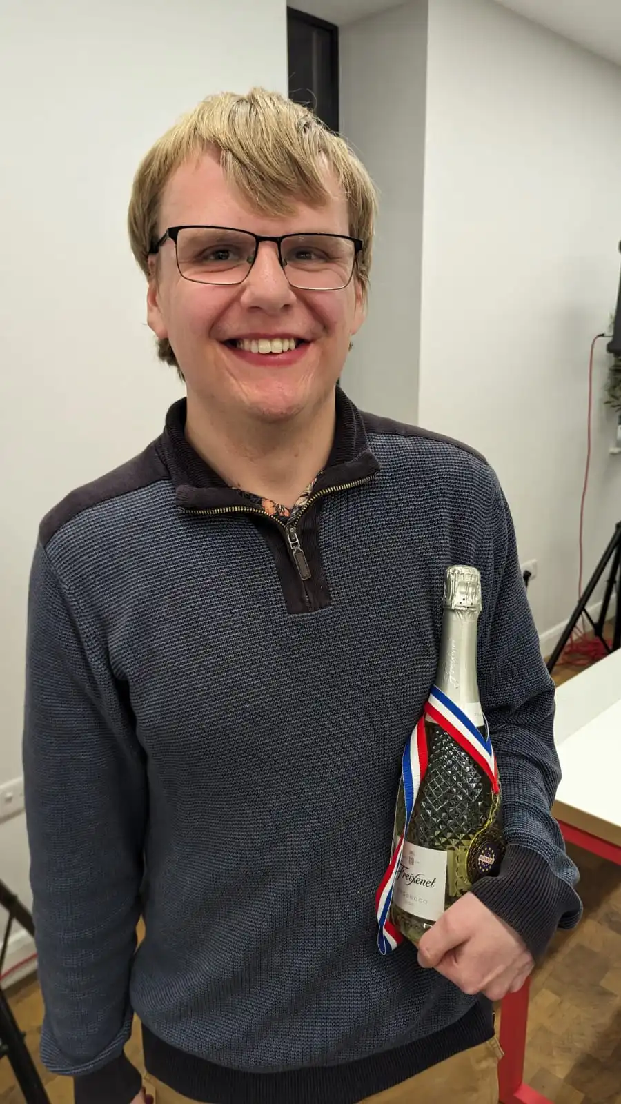 Me smiling with a bottle of Prosecco and a medal